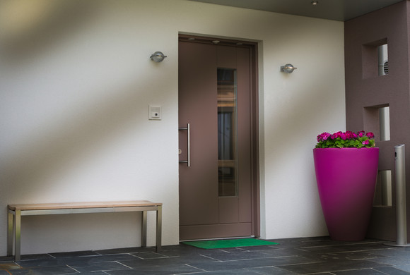 Nebojte se doplnit prostor kolem vchodových dveří barevnými květináči.