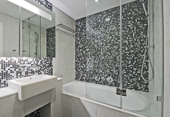 Moderní koupelna s vanovou zástěnou.